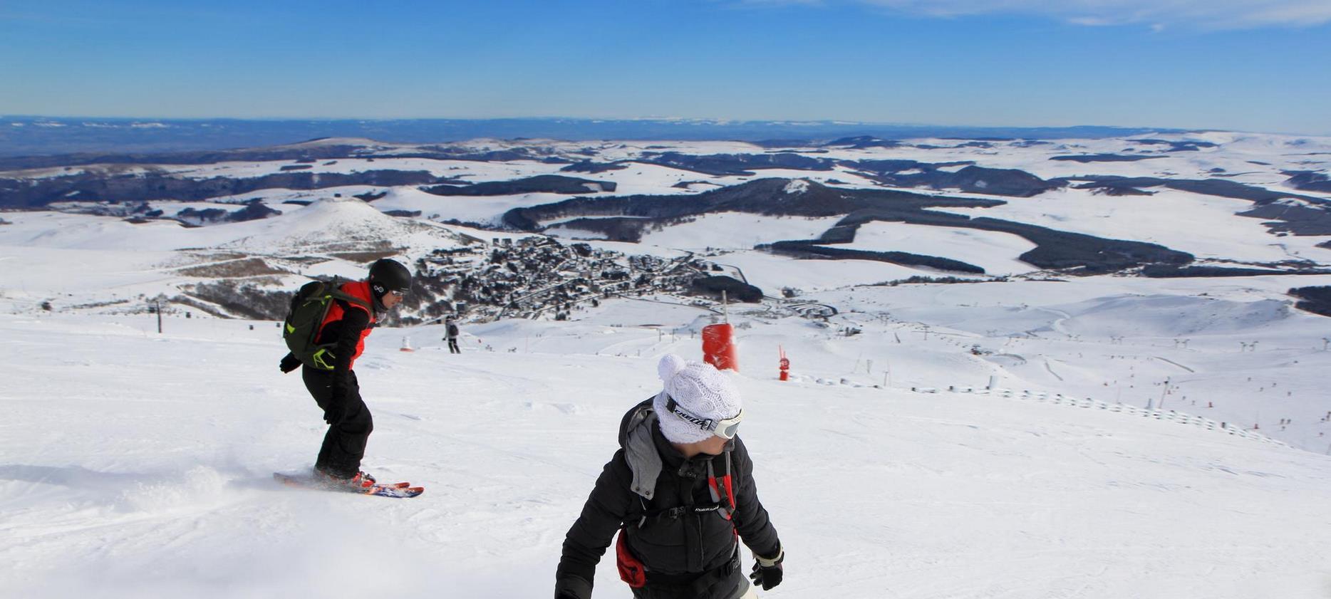 Super Besse - Snowboard sur les pistes de ski et vue sur le centre de la station Super Besse