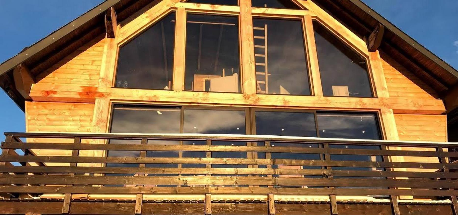 Chalet Super besse - Vue de la facade du chalet avec pignon en baies vitrees