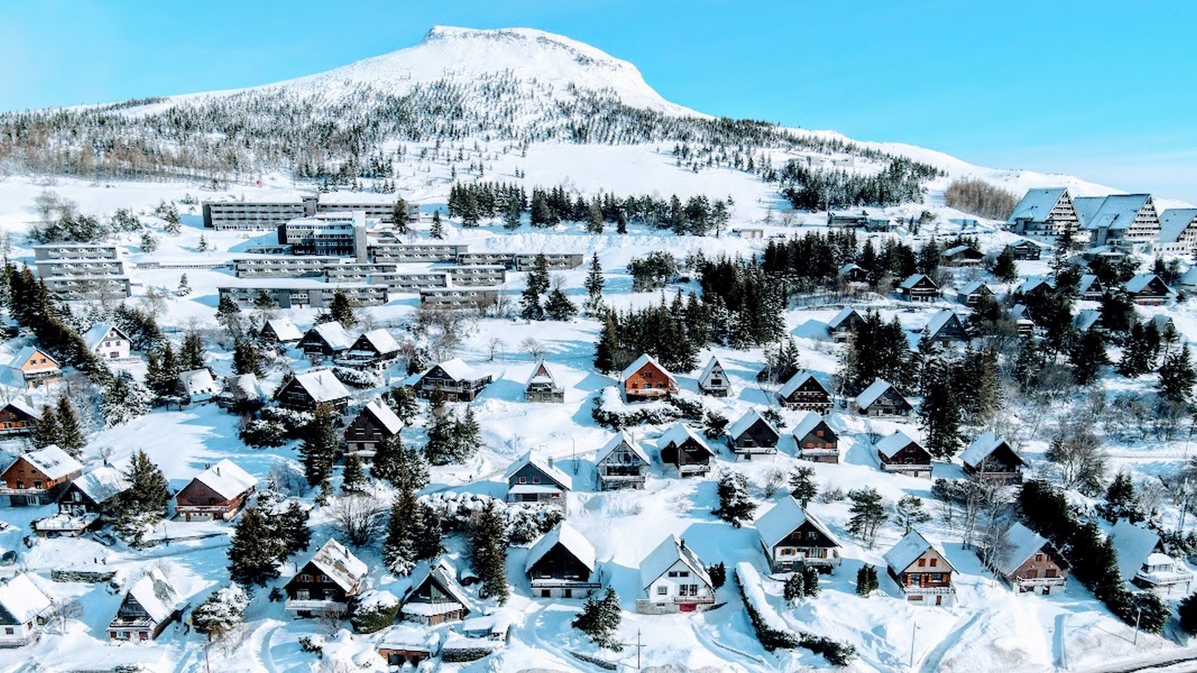 Large panorama sur le village de chalet de la station de Super Besse durant la saison d'été