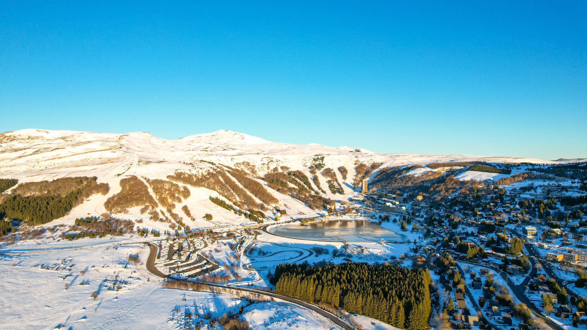 Super Besse vue du ciel, l'Aire de camping-car de Super Besse et le Lac des Hermines sous la neige