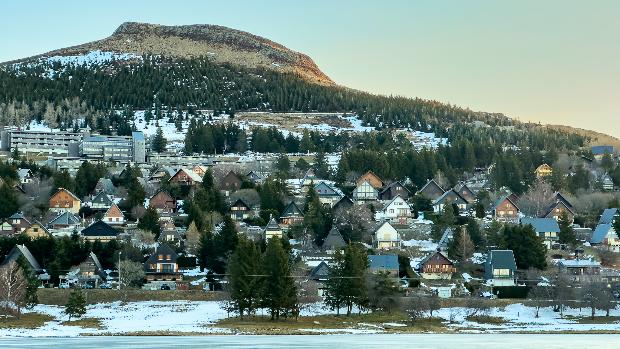 La lumière du soleil matinal se pose sur le village de chalet à Super Besse