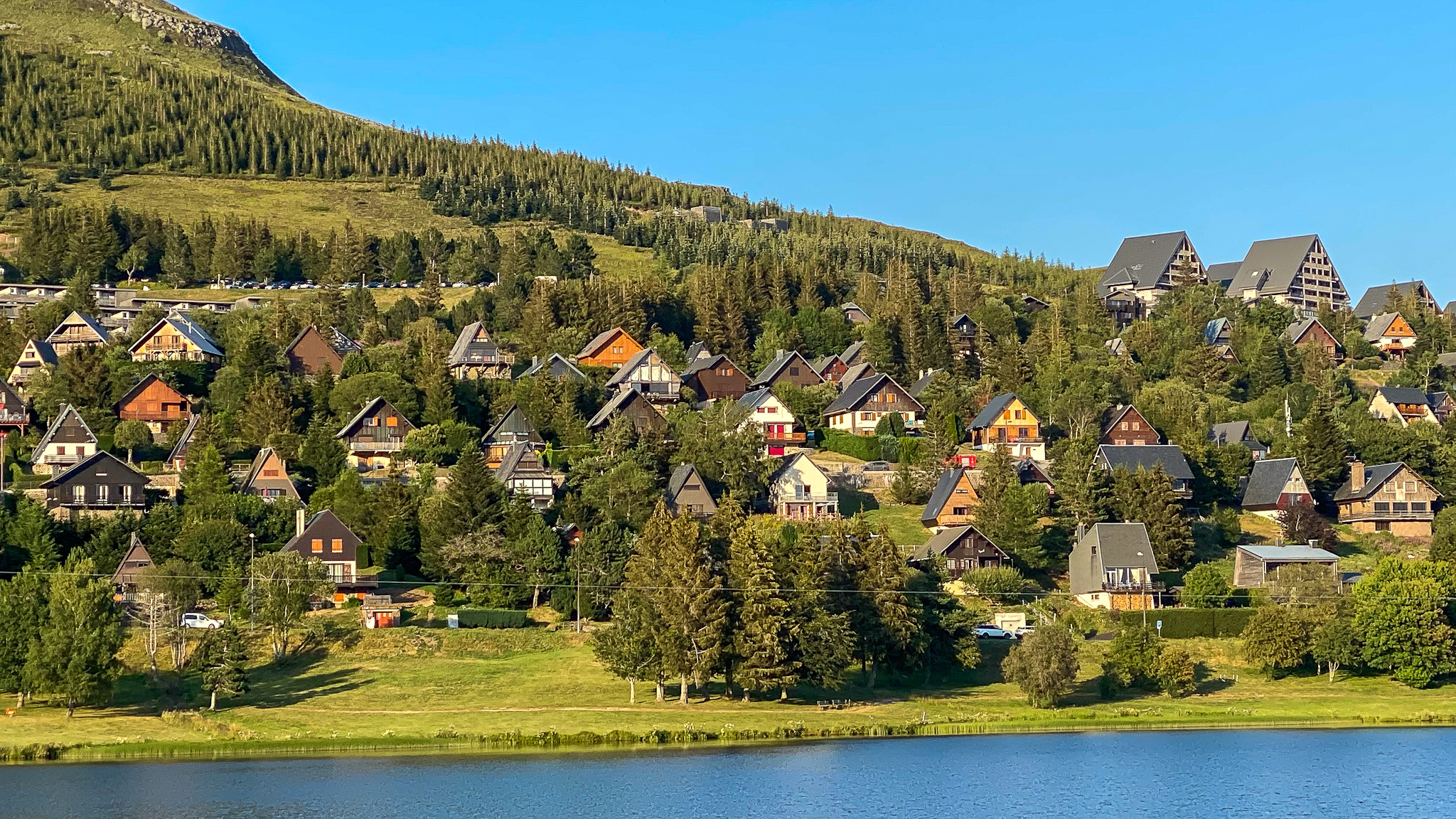 Juillet, le village de chalet à Super Besse au bord du lac des Hermines